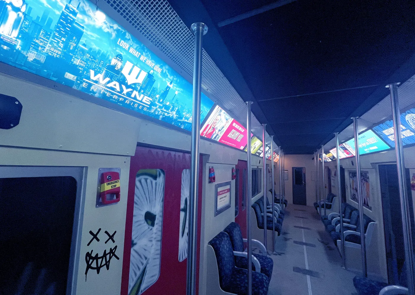 Themed subway car interior with blue Wayne Enterprises light panels.