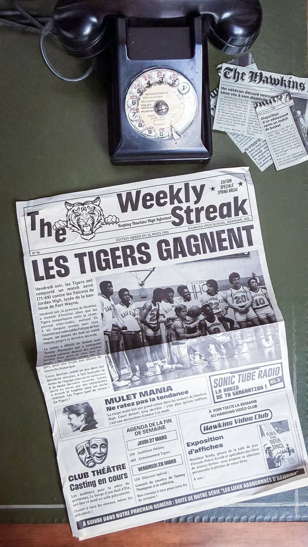Vintage rotary telephone beside The Weekly Streak, a fictional Hawkins newspaper.
